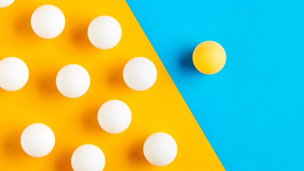 Table tennis balls in contrast. Diversity, difference, opposition, exclusion or confrontation concept.