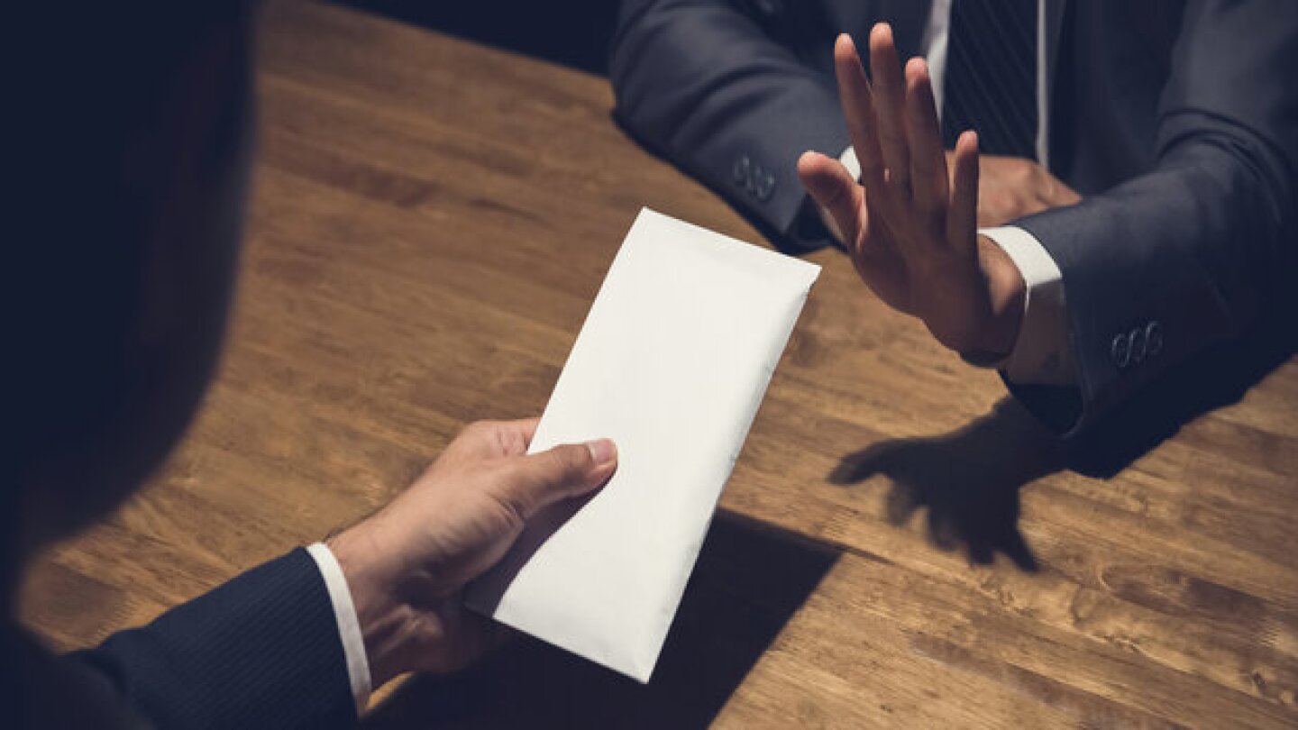 Businessman rejecting money in white envelope offered by his partner in the dark, anti bribery concept - panoramic banner