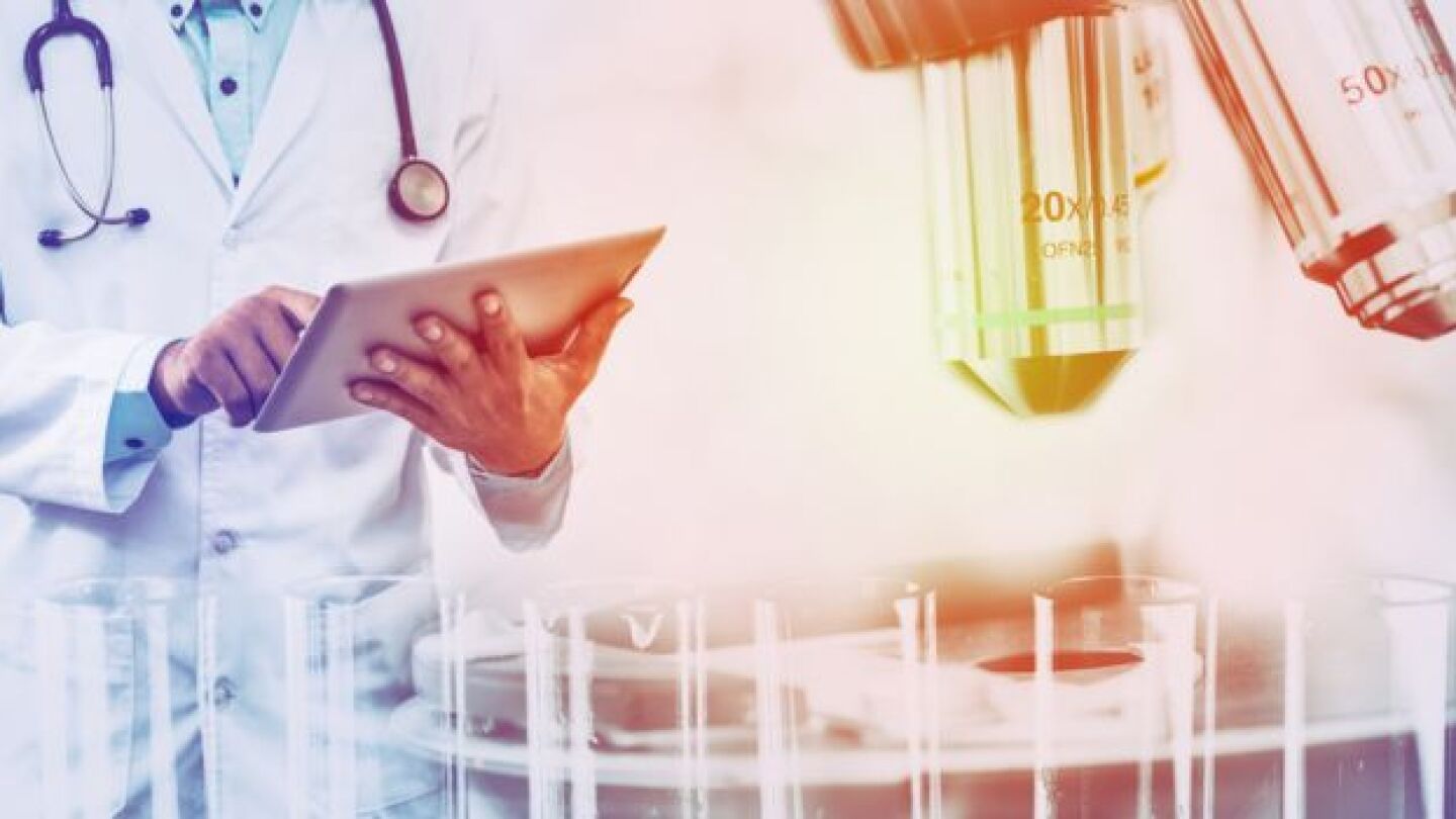 Pictured: Man holding tablet computer with scienti