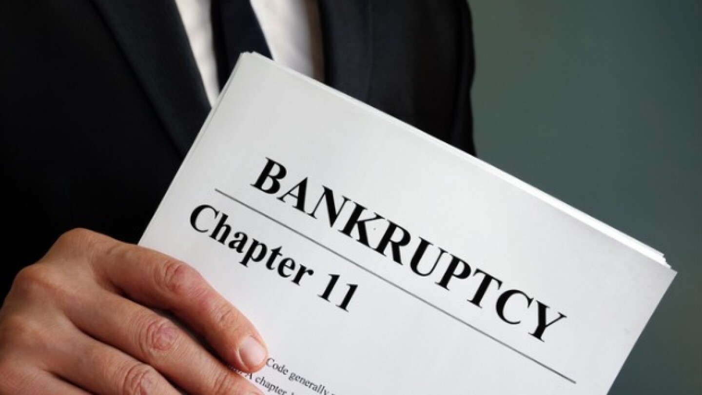 Pictured: Man holding a Chapter 11 bankruptcy filing