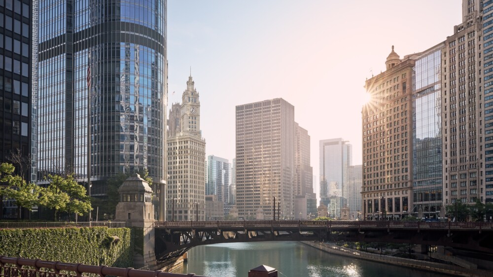 Bridges over Chicago River amidst skyscrapers at sunrise