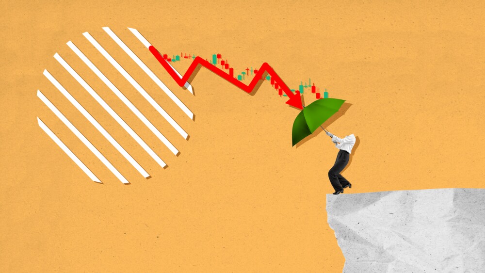 A man is holding an umbrella while standing on a cliff. The umbrella is green and the man is looking up at the sky. Concept of danger and uncertainty, as the man is on the edge of a cliff