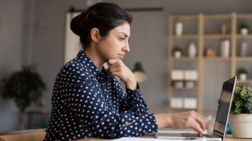 A young woman working on a laptop computer/iStock,