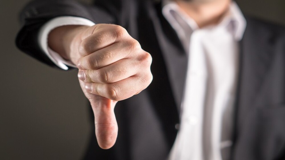 Businessman showing thumbs down.
