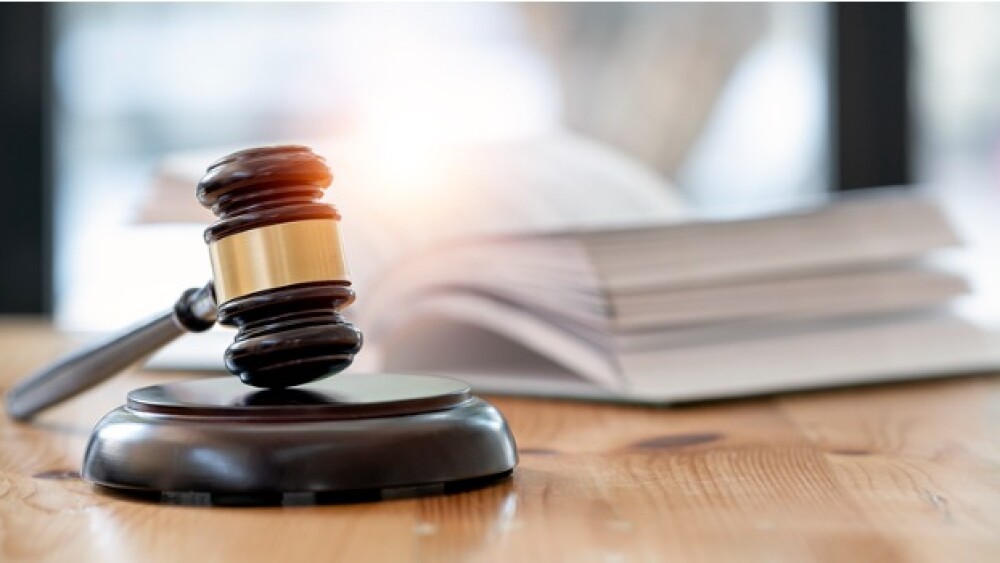 Pictured: A wooden gavel on a table with a book in