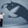 Business man afraid of his own shadow monster concept on grungy background