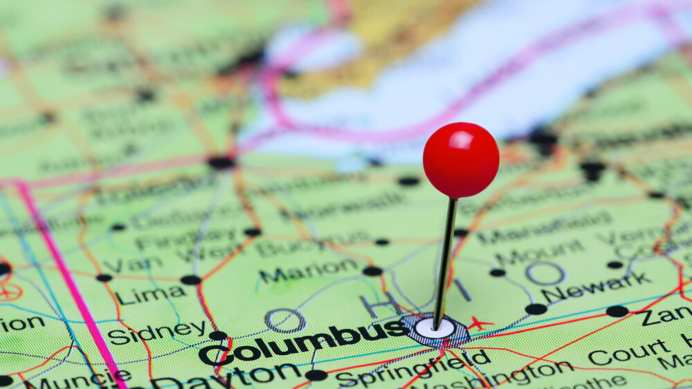 Photo of pinned Columbus on a map of USA. May be used as illustration for traveling theme.