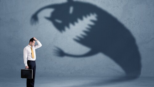 Business man afraid of his own shadow monster concept on grungy background