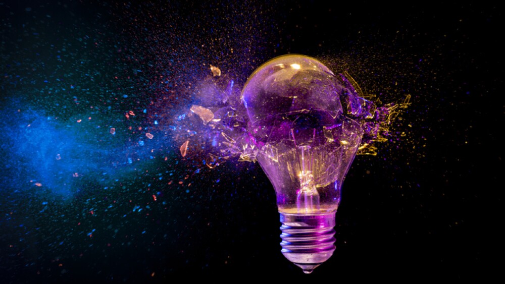 Colorful light bulb exploding glass flying everywhere black background