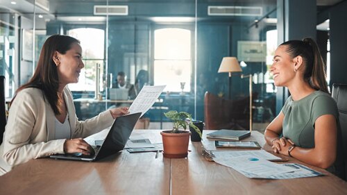 Pictured: Two women attend a meeting so the direct report can manage up