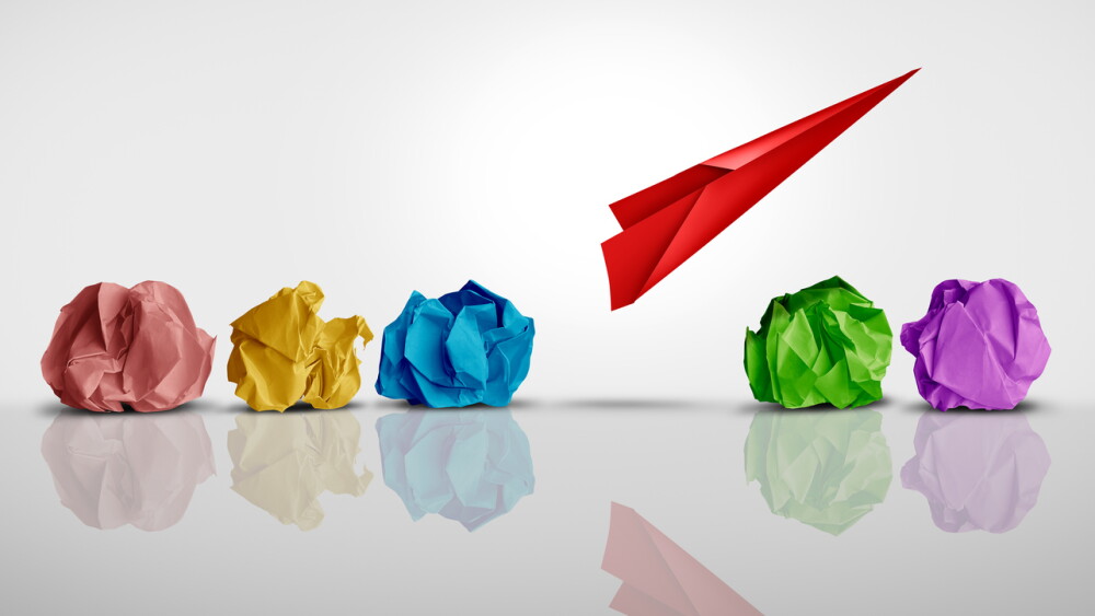 Developing Business Potential and Individual creativity concept and creative innovator or new thinking as a symbol of innovation and inspiration metaphor as a group of crumpled papers with one different paper transforming into an airplane.