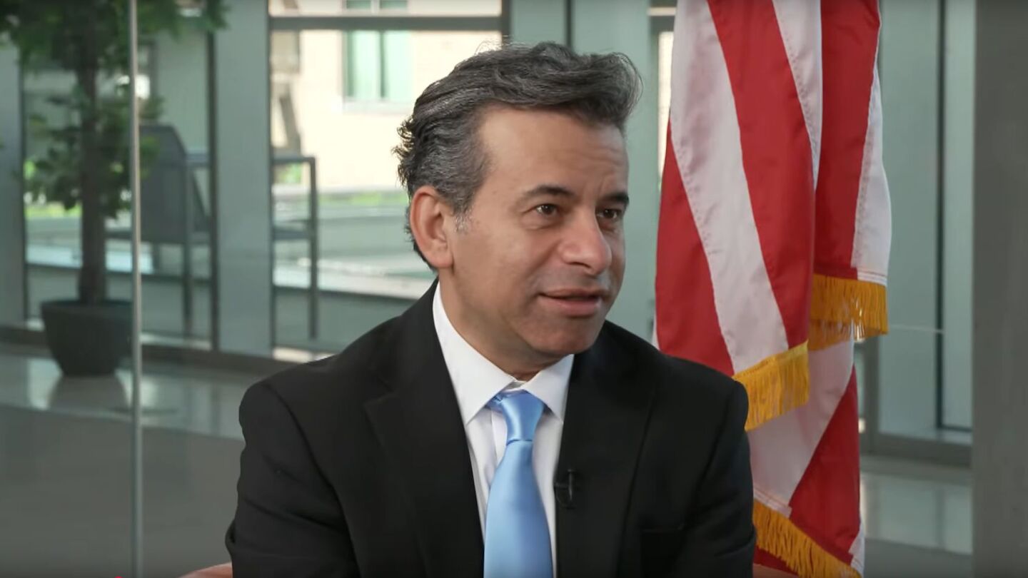 FDA commissioner Marty Makary speaking on a Youtube video, wearing a dark suit and a blue tie