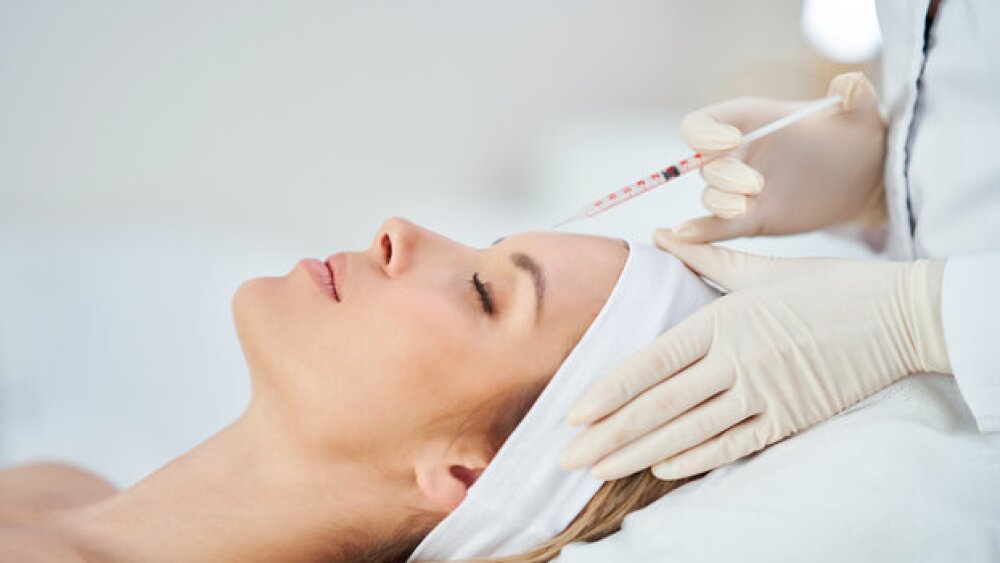 Pictured: Doctor injecting Botox into the forehead