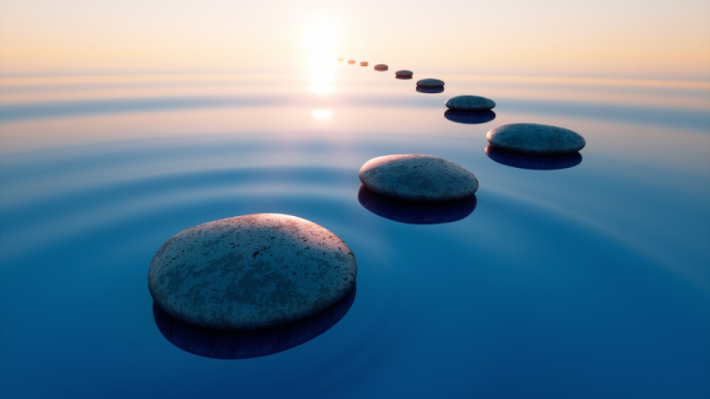 Stones in calm water with evening sun