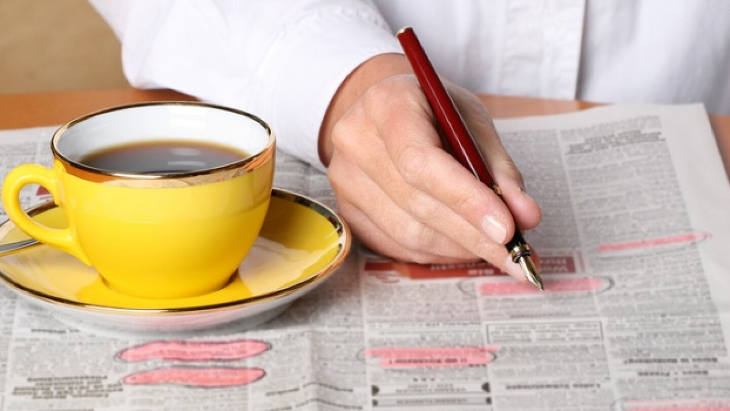 person searching for ads and job in the newspaper