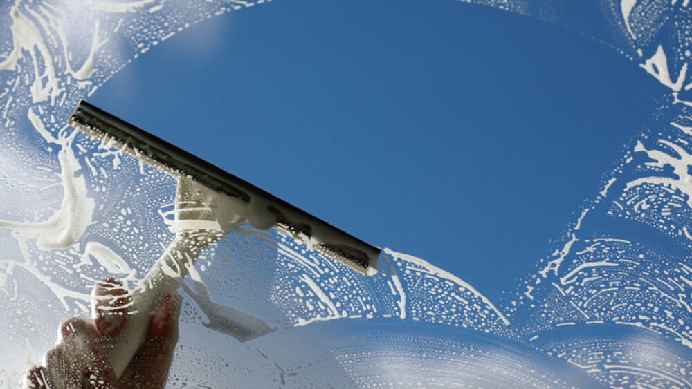 Window cleaner using a squeegee to wash a window