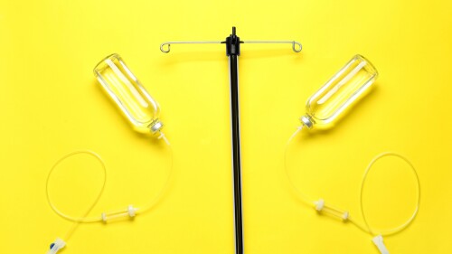 IV infusion set on yellow background, flat lay