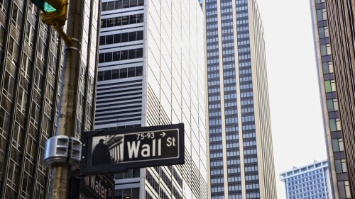 Wall Street sign with a background of skyscrapers in Lower Manhattan, New York City