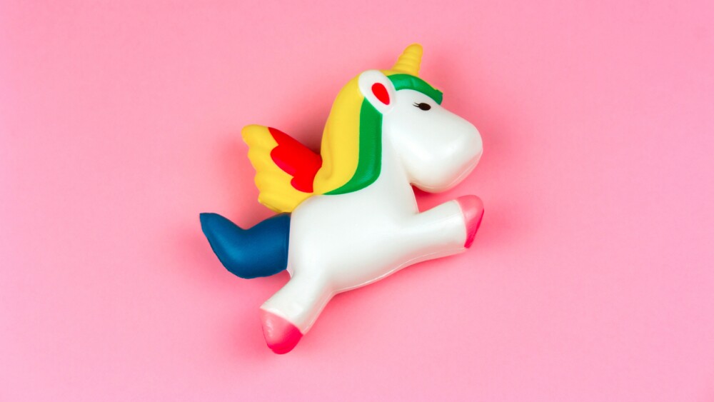 top view squishy unicorn toy on a pastel pink background