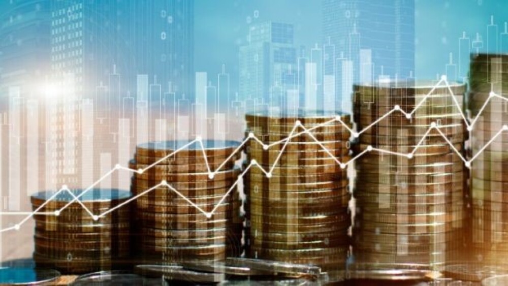 Pictured: Stack of coins with trading graph/iStock