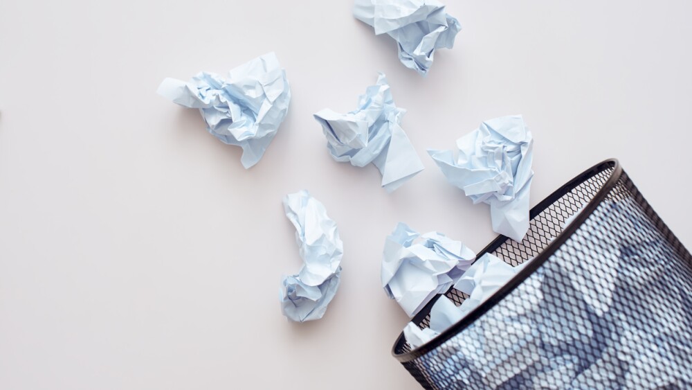 Sorting garbage concept. Cropped photo of paper thash. Crumple paper falling to the recycling bin