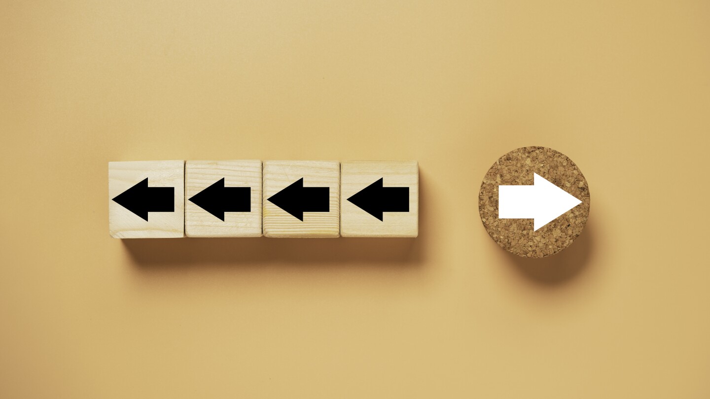 White arrow on circle wooden move on different direction with black arrow on cube for business and technology disruption concept.