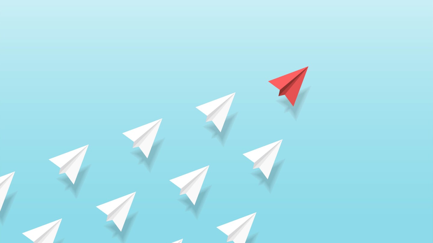 Illustration of red paper plane leading white paper planes up into the sky