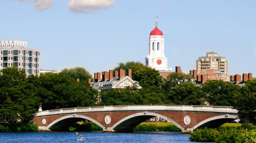 Image of Harvard University and pedestrian bridge on Charles River in Cambridge, Massachusetts