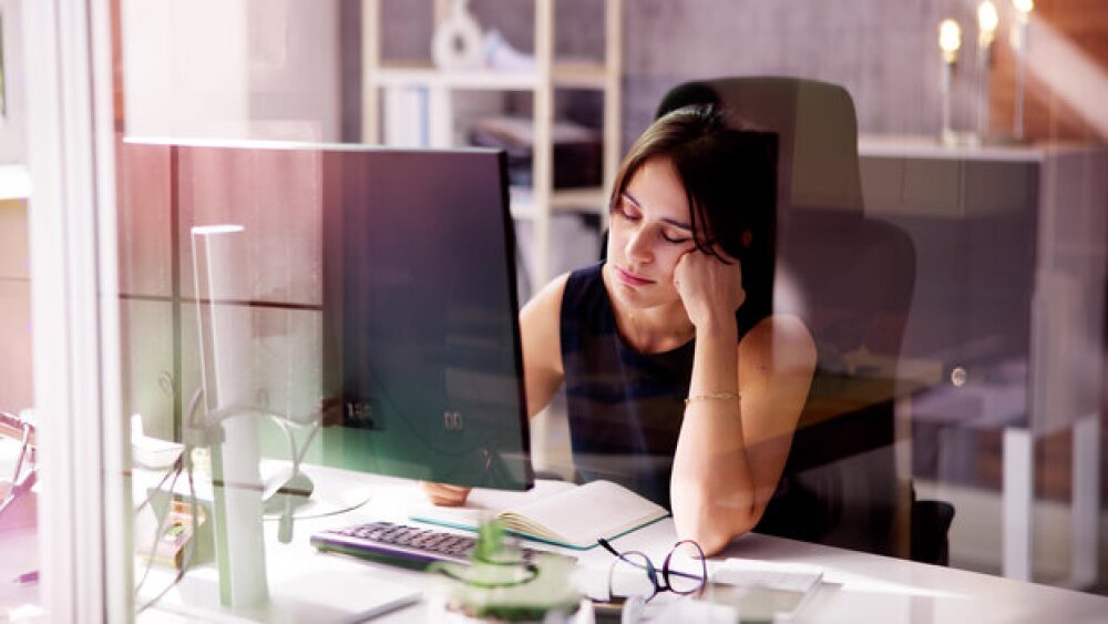 Pictured: Woman falling asleep at her workstation/