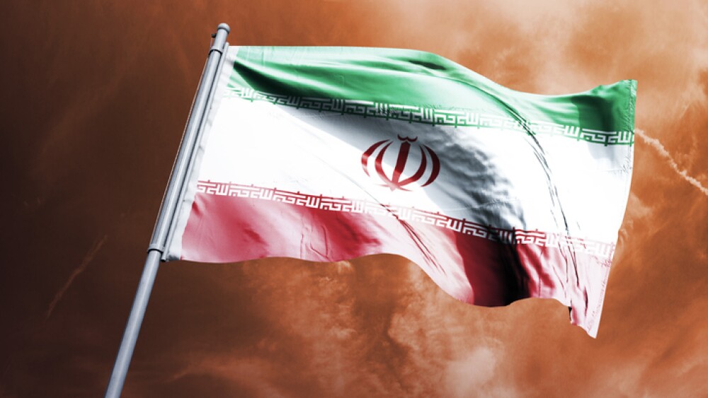 Iranian flag against a burning sky