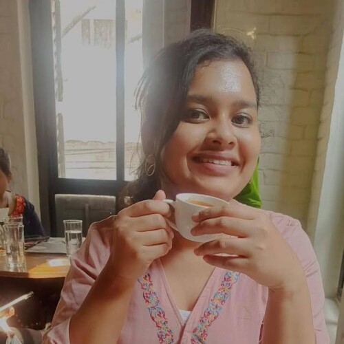 Sanjukta Mondal holding a coffee cup and smiling