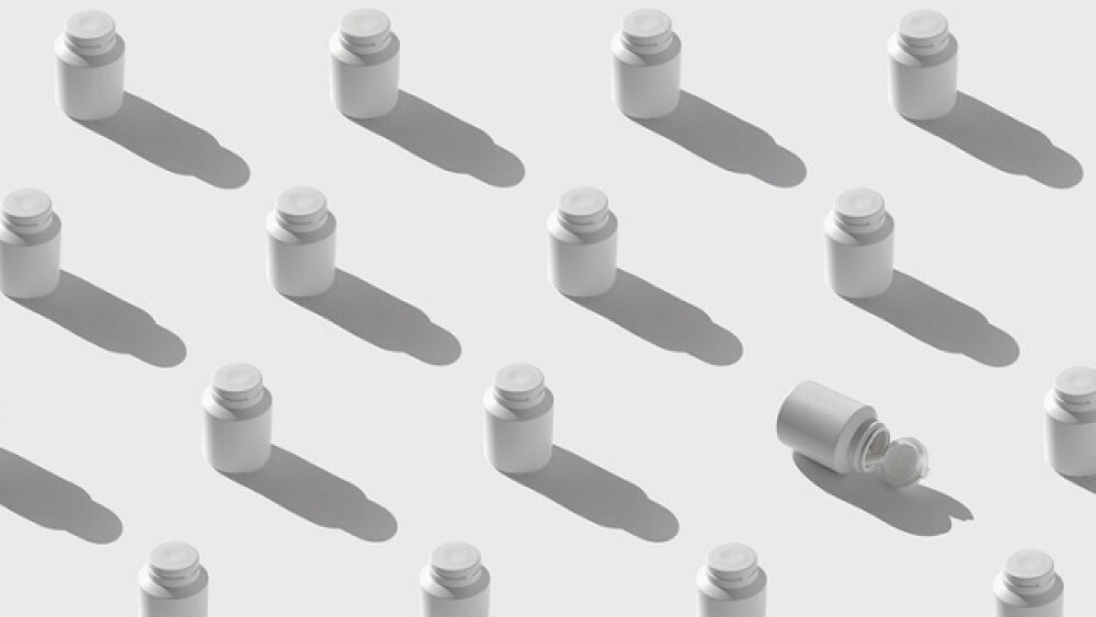 Minimal style pattern made of white plastic bottles for supplement, vitamin, pills on sunlit background with shadow. Set of containers packaging with a cap. Pharmacy and medicine concept