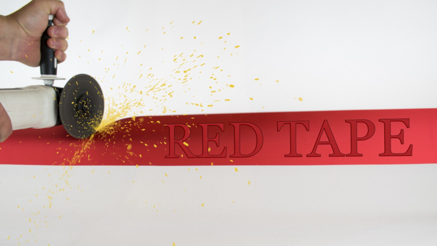 Circular handsaw cutting through a strip of red tape