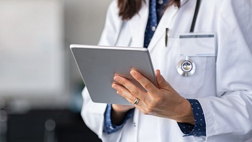 Pictured: Doctor holding tablet/Ridofranz/iStock