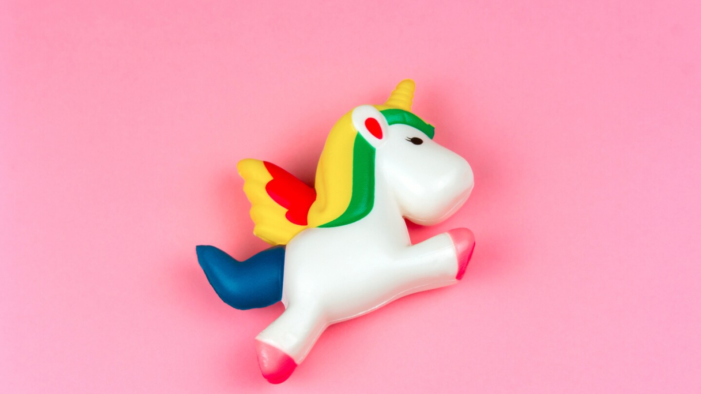 top view squishy unicorn toy on a pastel pink background