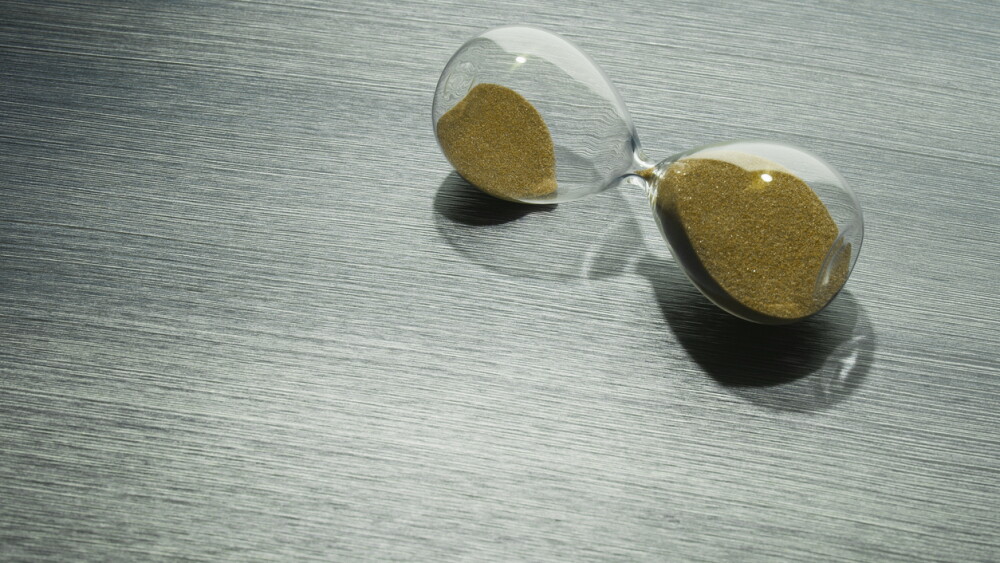 Time on the hourglass stopped. Clock on table. Pause in business, collapse.