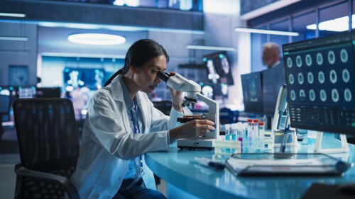 Photo of female scientist using microscope